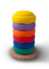 Sechs bunte Stapelsteine aufeinander gestapelt auf einem bunten Balanceboard.
