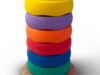 Sechs bunte Stapelsteine aufeinander gestapelt auf einem bunten Balanceboard.